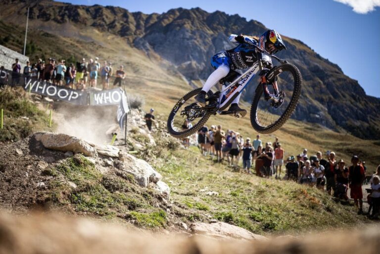 un pilote de vtt de descente pris en photo dans un saut lors de la coupe du monde de DH au Canada